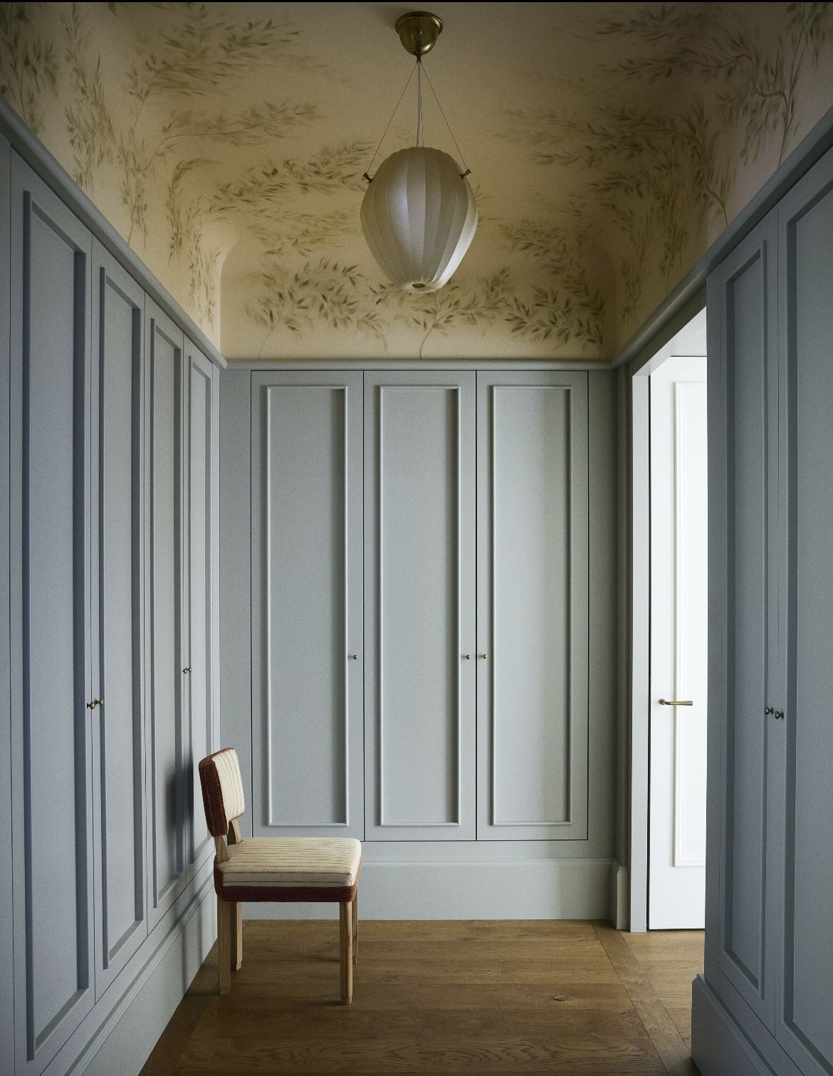 Calm storage room with paneled cabinets and a chair